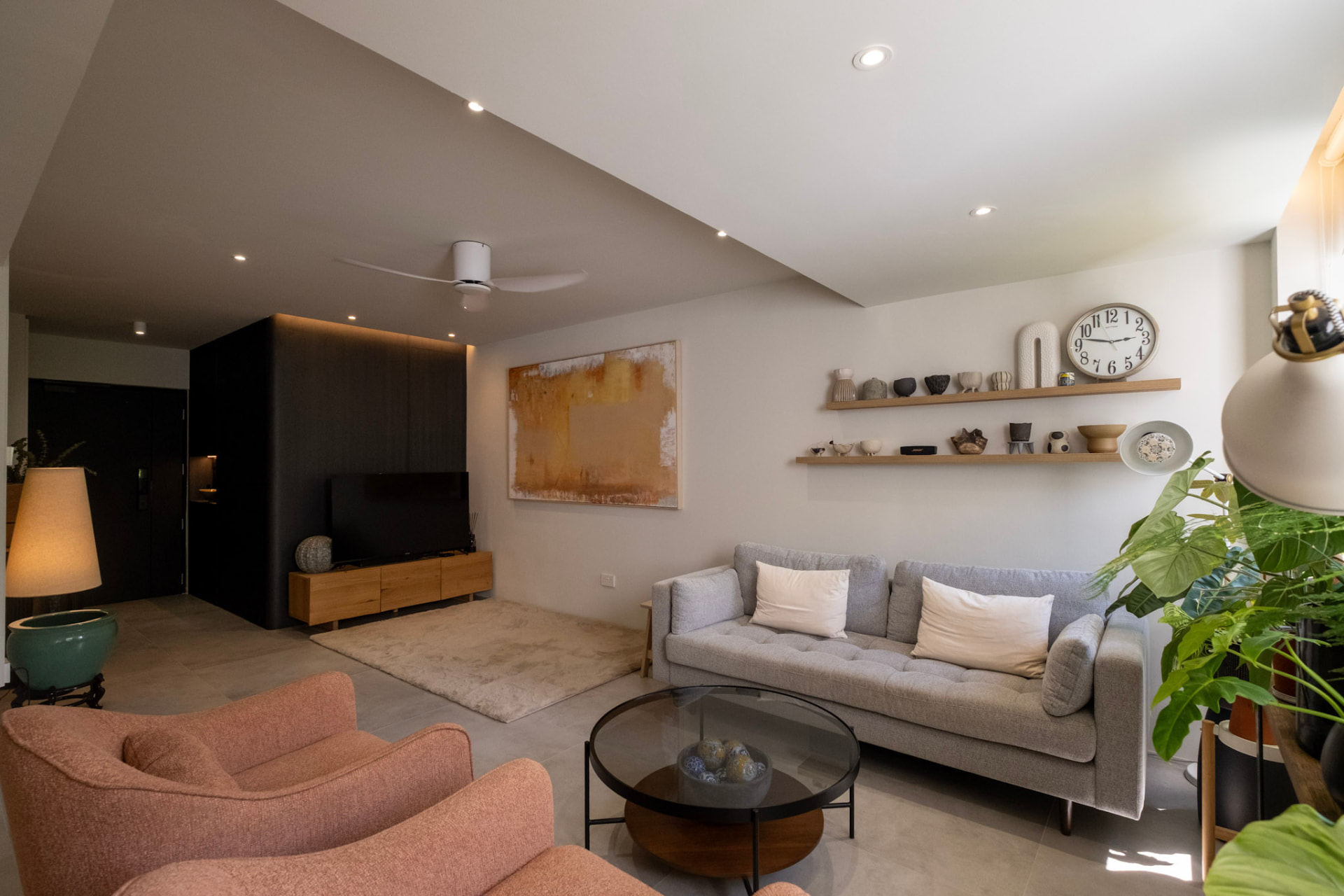 Modern Singapore living room with warm wood paneling and rattan armchairs